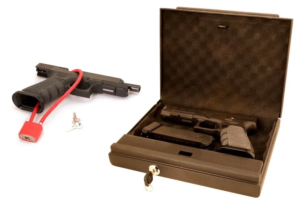 A handgun with a red cable lock, a set of keys, and a black pistol case containing a firearm and magazine.